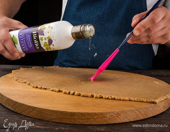 Рабочую поверхность посыпать оставшейся мукой, выложить тесто, вымесить его руками и раскатать из теста пласт толщиной в 1 см.