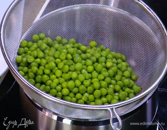Размороженный зеленый горошек опустить на несколько минут в кипящую воду, затем откинуть на дуршлаг.