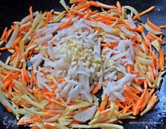 Обжариваем немного, помешивая и теперь добавляем дайкон и измельченный чеснок, перемешиваем.