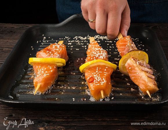 Лимон нарежьте тонкими кружочками. Нанизываем в таком порядке: кусочек лимона, затем рыбу и опять кусочек лимона. Обсыпаем рыбу кунжутными семечками. Жарим на сковороде-гриль 4–5 минут. 