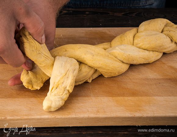 Косу заплести и уложить на противень швами вниз. Оставить на подъем еще на 1 час. Смазать тесто смесью желтка с молоком/сливками. Выпекать в предварительно разогретой до 180 °С духовке примерно 30 минут. 

