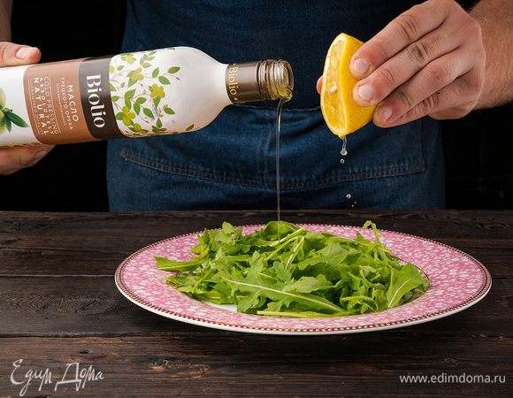 Руколу необходимо заранее вымыть и высушить. Уже высушенную руколу выложить на тарелку, на которой будете подавать салат, сбрызнуть лимонным соком и полить 1 ст. л. масла грецкого ореха.
