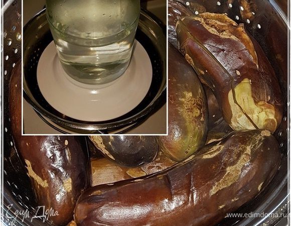 Сложить баклажаны в дуршлаг, накрыть тарелкой и поставить сверху не очень тяжелый гнет. Чтобы ягоды не помять, но влагу излишнюю выдавить.

