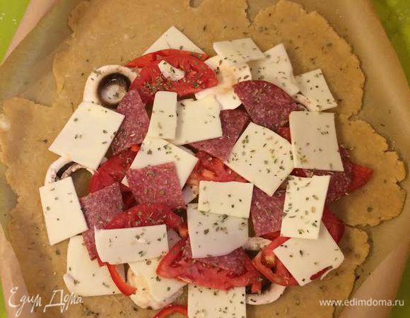 Выложить начинку, сверху посыпать орегано.