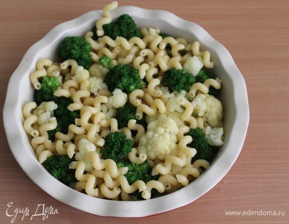 Макароны отварить до полуготовности, овощи бланшировать 2 — 3 минуты в кипящей, подсоленной воде. Выложить макароны и овощи в форму для выпечки.
