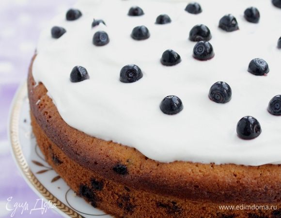 Взбить сахарную пудру с творожным сыром, если получилось слишком густо, можно добавить немного сметаны. Нанести на кекс. Посыпать оставшейся ягодой.