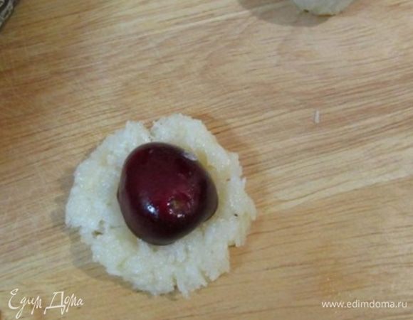 С помощью весов разделить массу на 18 равных кусочков (у меня по 8 граммов). Из каждого кусочка формовать лепешку. В середину положить половинку вишни. 