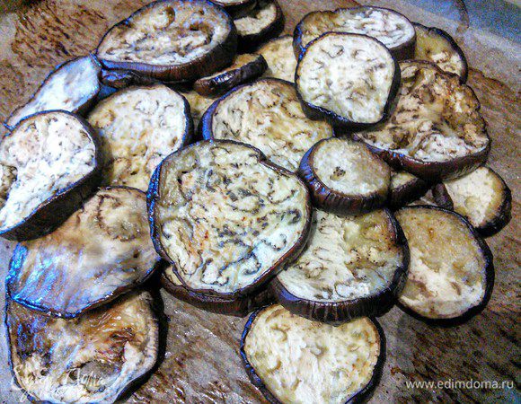 Баклажаны вымыть, нарезать кружочками. Посыпать солью, оставить на время. Затем промокнуть влагу, выложить на противень, сбрызнуть оливковым маслом  и запекать в течение 40 мин. или до готовности  в разогретой до 180°С духовке. В середине времени каждый кружочек перевернуть. 