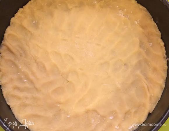 Духовку нагреть до 180°С. Форму (26 см) выстлать бумагой для выпечки. Большую часть теста распределить по форме.