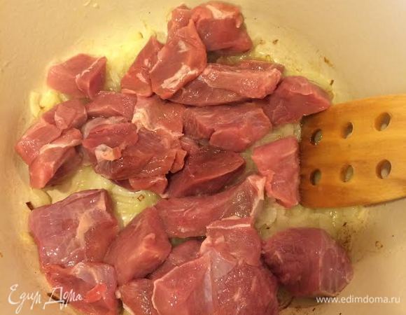 В кастрюле с толстым дном потушить лук до золотистого цвета. Затем добавить мясо и обжарить.