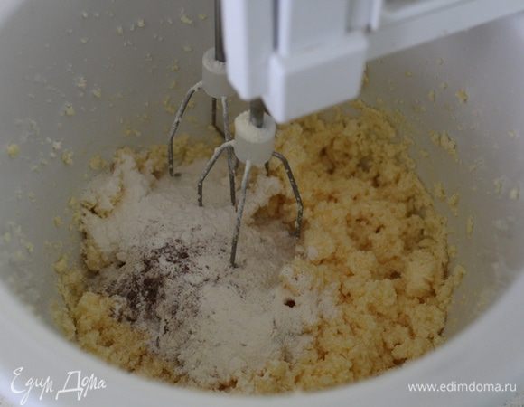 Масло взбить с сахаром, ванильным сахаром и яйцом. К смеси добавить половину муки и специй, продолжая взбивать.