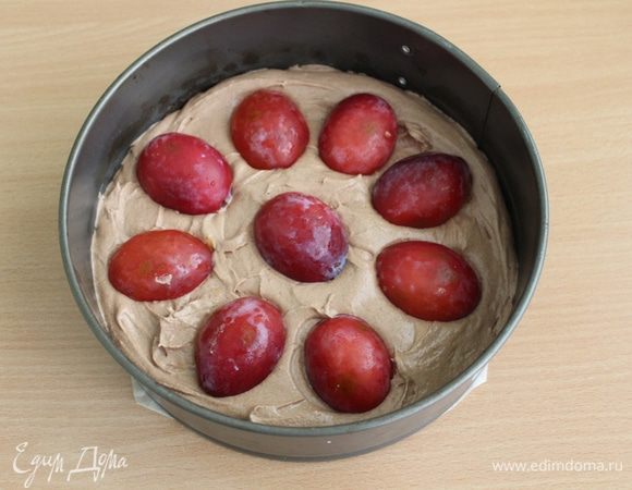 Вылить тесто в смазанную форму диаметром 20 см, сверху выложить половинки слив срезом вниз.