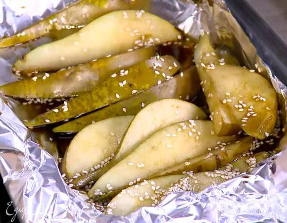 Небольшой противень выстелить пищевой фольгой, разложить дольки груши, полить их оставшейся в миске пряной заправкой и запекать под разогретым грилем до полуготовности.