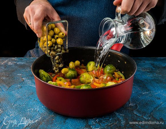 Влить 3/4 литра воды и брюссельскую капусту. Добавить зеленые маслины и каперсы. Тушить 10 мин.