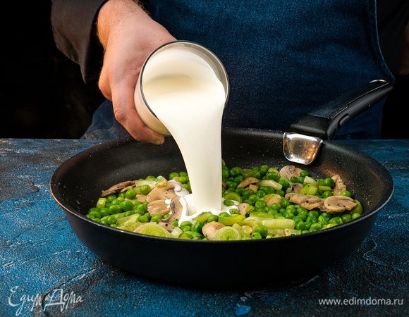 Добавить зеленый горошек, продолжая обжаривать. Влить сливки и потушить все минут 5, посолить по вкусу.
