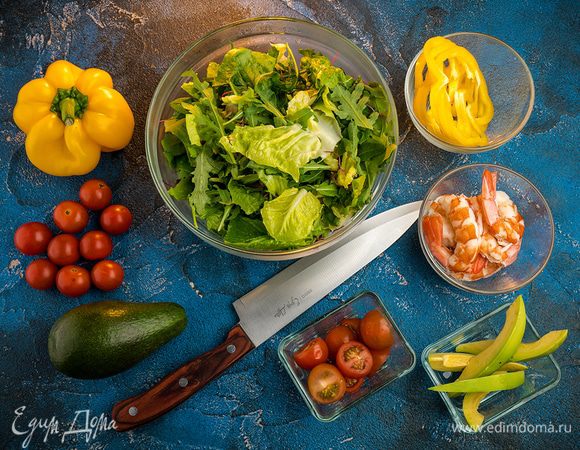 Салат порвать руками большими кусочками, добавить руколу. Перец нарезать кружочками, помидоры нарезать кружочками и пополам, авокадо натереть на терке или нарезать мелкой соломкой.