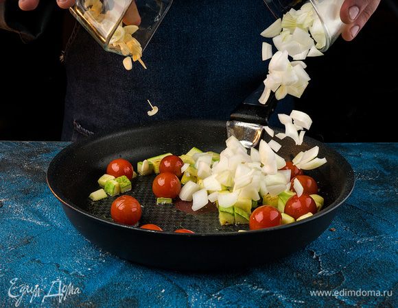 На сковороде разогреть оливковое масло. Обжарить кабачки и помидоры черри. Затем добавить в сковороду лук, чеснок, креветки, жарить 4 мин., пока креветки не изменят цвет.
