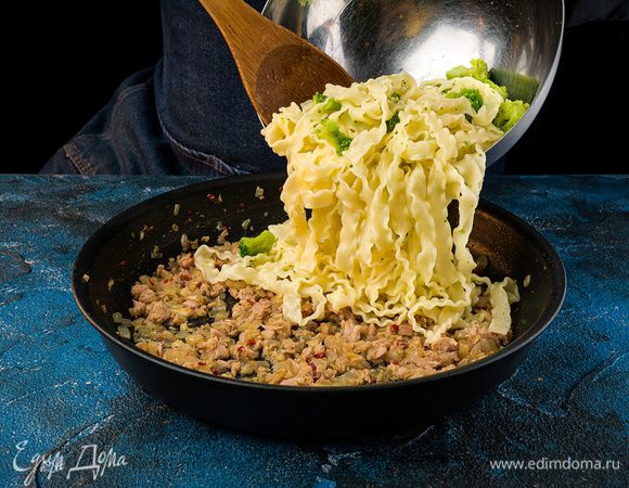 Откинуть на дуршлаг, соединить с луком и чесноком. Тунец  хорошо перемешать и прогреть на слабом огне 1 минуту.  Посыпать пармезаном. 