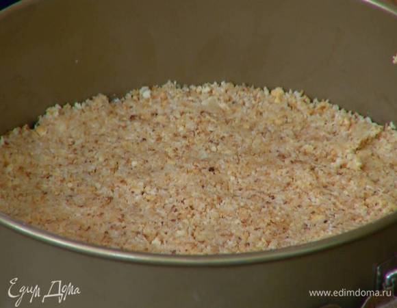 Дно разъемной формы для выпечки выстелить пищевой пленкой, равномерно распределить печенье слоем в 3‒5 мм и отправить в морозильник.