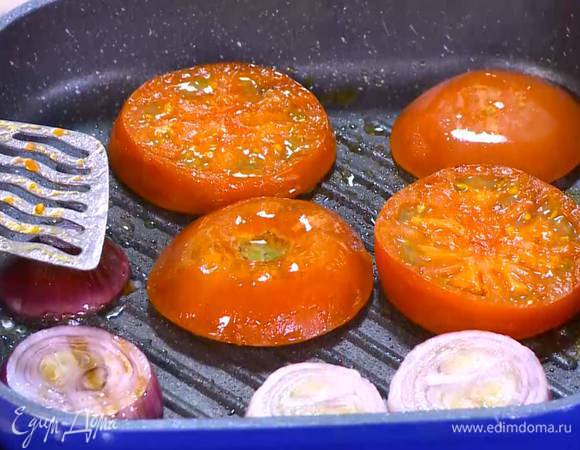 Разогреть в сковороде-гриль 1‒2 ч. ложки оливкового масла и обжаривать лук и помидоры с двух сторон до появления золотистой корочки.
