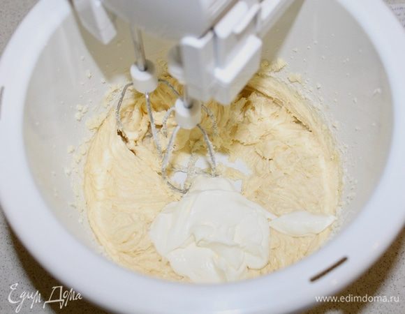 Затем добавить половину просеянной с содой, солью и разрыхлителем муки, перемешать, добавить сметану и снова взбить.
Добавить оставшуюся муку. 