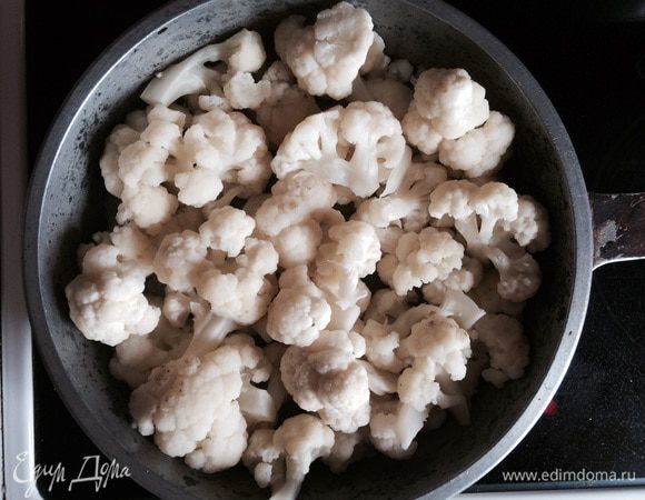 Цветную капусту разбираем на соцветия, отвариваем в кипящей подсоленной воде 5-7 минут, сливаем и выкладываем в форму для запекания. 