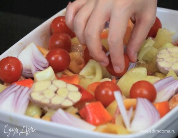 Выложить половинки головки чеснока поверх овощей и добавить целые помидорки. Убрать в духовку на 50 минут.