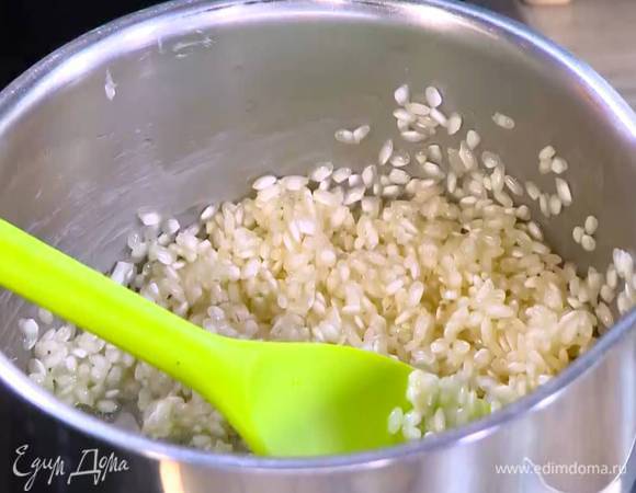 В кастрюле среднего размера растопить сливочное масло, затем всыпать рис и слегка прогреть, чтобы он пропитался маслом и стал прозрачным.