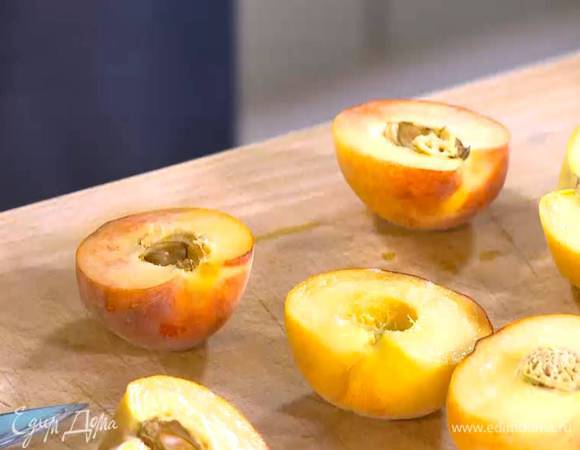 Персики разрезать пополам и удалить косточки.
