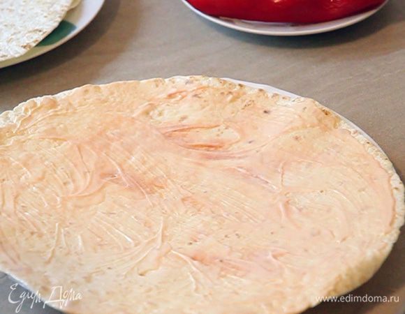 Берем один лаваш. Смазываем его майонезом и небольшим количеством кетчупа. Равномерно наносим смесь майонеза и кетчупа на поверхность лавашика.