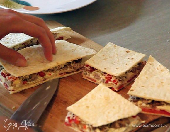 Берем доску и перекладываем полученный лавашик на нее. Разрезаем его сначала пополам. И одну половину убираем в холодильник. Со второй половиной начинаем работать: разрезаем ее на небольшие кусочки.