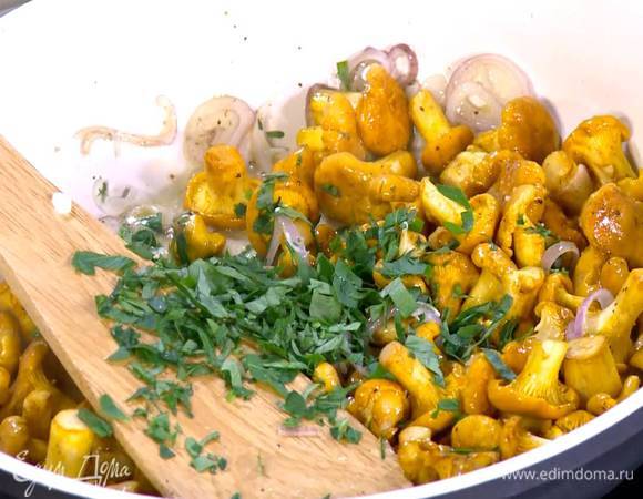 Петрушку мелко порубить, добавить в сковороду с лисичками, все перемешать и жарить грибы до готовности.