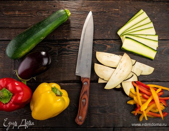 Баклажан и цукини нарезать вдоль тонкими пластинами. Сладкий перец, удалив плодоножку с семенами, нарезать крупными полосками.
