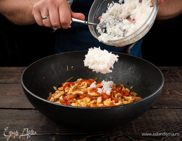 В готовую смесь высыпаем рис, тщательно перемешиваем и на большом огне обжариваем. 