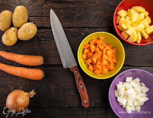 Помойте и очистите морковь и картофель. Овощи нарежьте кубиками или небольшими кусочками. Сложите в кастрюлю.
