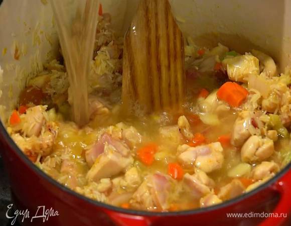 Курицу с рисом залить горячим куриным бульоном, так чтобы все было покрыто жидкостью, накрыть кастрюлю крышкой и готовить на медленном огне.