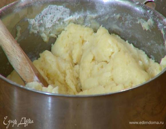 Снять кастрюлю с огня, всыпать муку и деревянной ложкой вымешать тесто.