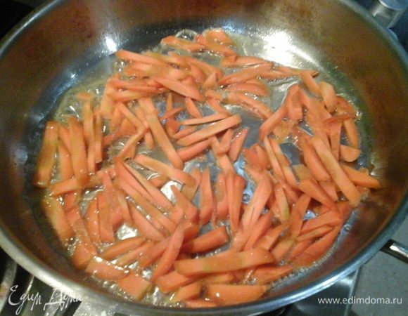 Нашинковать морковь. Растопить в раскаленной сковороде сливочное масло. Обжарить морковь до легкой золотистой корочки. Добавить лук и притомить 5 минут.