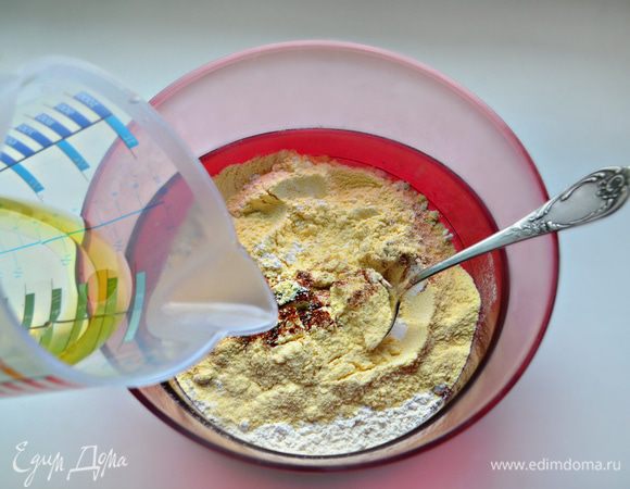 Для приготовления теста необходимо просеять кукурузную и пшеничную муку, добавить соль, молотую паприку и перемешать. Добавить теплую воду с маслом, всыпать муку и перемешать.  