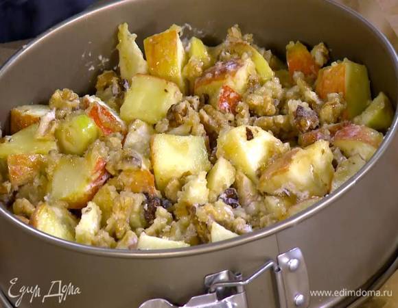 Дно разъемной формы для выпечки выстелить пищевой бумагой, равномерно выложить тесто, а сверху яблочно-ореховую начинку.