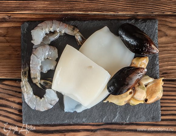 Заранее нужно сварить куриный бульон. Если бульон заморожен — разморозить и довести до кипения. Также необходимо разморозить морепродукты.