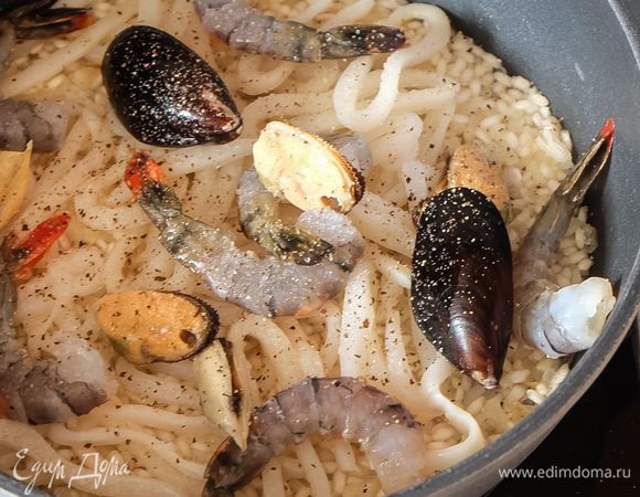 У нас остался последний половник бульона. Перед его добавлением кладем в рис морепродукты. Не перемешиваем, просто «утапливаем» их в рис, то есть они должны быть на поверхности.