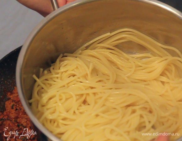 Сливаем со спагетти воду. Добавляем кусочек сливочного масла (либо 1 ч. л. растительного) и хорошо перемешиваем.
