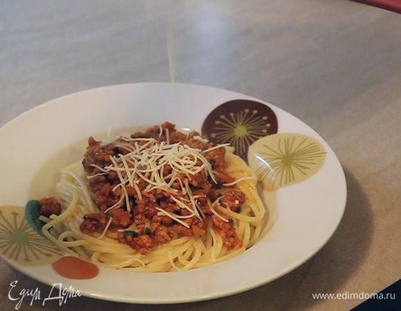 Приступаем к формированию отдельных порций. На дно тарелки кладем желаемое количество спагетти. Сверху выкладываем соус и посыпаем мелко натертым твердым сыром.
