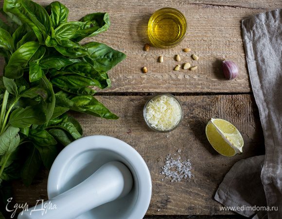 Базилик промойте и тщательно просушите. В чашу блендера сложите листья базилика, кедровые орешки, чеснок и сок лимона, измельчите до получения однородной массы.