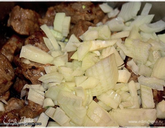 Потом выкладываем мясо в кастрюлю. Туда же отправляем нарезанный лук.