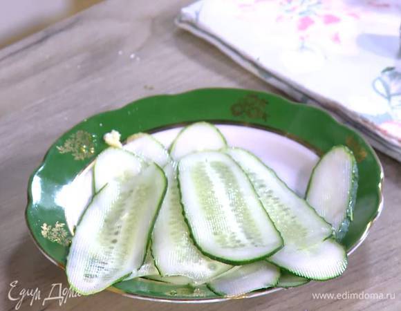 Огурец нарезать вдоль тонкими полосками (можно воспользоваться овощечисткой).