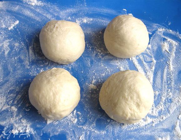 Вынуть из холодильника. Снять пленку, на ней будет конденсат. Накрыть полотенцем, дать постоять при комнатной температуре 1,5 часа. Рабочую поверхность присыпать мукой. Тесто разделить на 4 одинаковых по размеру шара, дать постоять минут 15 под полотенцем. 
