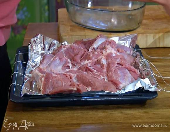 Противень выстелить пищевой фольгой, разложить 3‒4 пищевые нити, так чтобы концы свешивались, сверху поместить телятину, на нее равномерно выложить фарш.