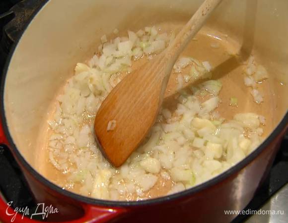 Разогреть в тяжелой кастрюле оливковое масло и обжарить лук и чеснок.